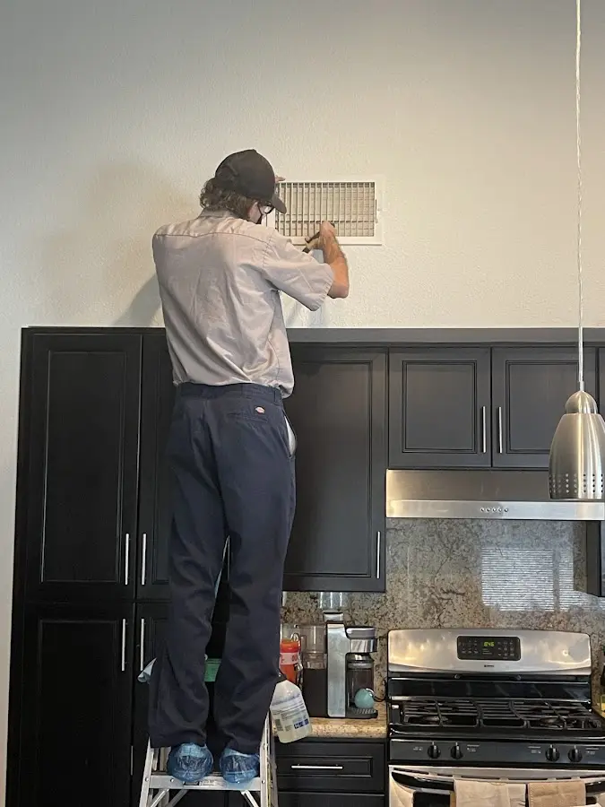 Technician inspecting an air vent during HVAC service in Rockwood